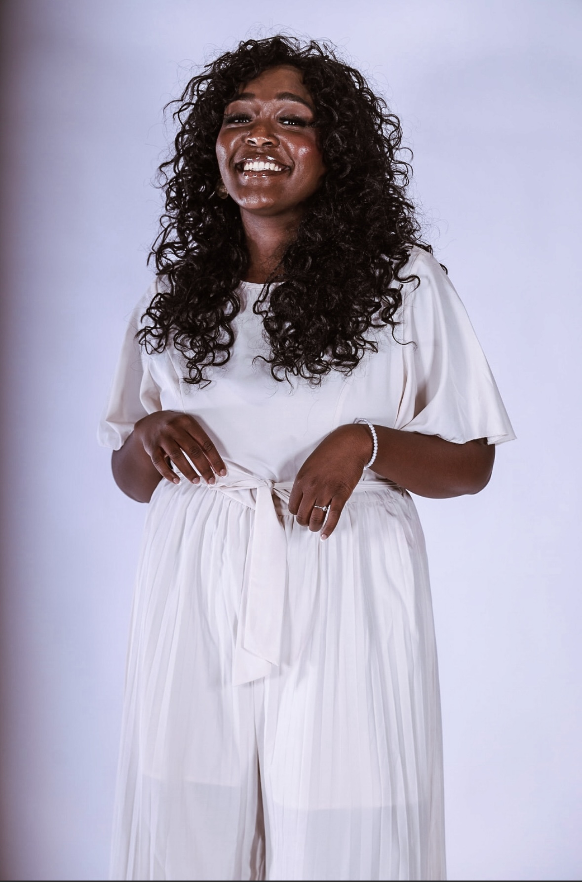 Alexis, the baker behind Mighty Taste Factory, smiling in her kitchen whites